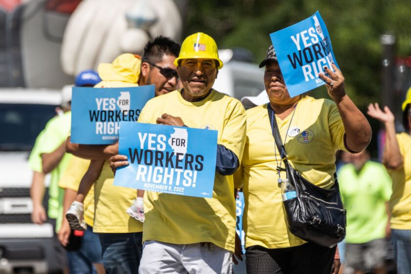   Os participantes do desfile seguram uma placa que diz: “Sim pelos direitos dos trabalhadores!” enquanto eles marcham pela South Ewing Avenue no East Side durante a Parada do Dia do Trabalho em 2 de setembro. Centenas de trabalhadores sindicais e simpatizantes se juntaram ao desfile.