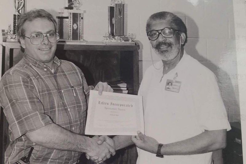 Joe Coleman (höger) får en utmärkelse från Menard Correctional Center Warden Thomas F. Page.