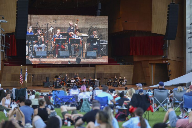   La gente si rilassa nell'erba mentre Mike Allemana e la band eseguono la musica dal suo album 'Vonology' durante il Chicago Jazz Festival al Pritzker Pavilion nel Millennium Park giovedì 1 settembre 2022.