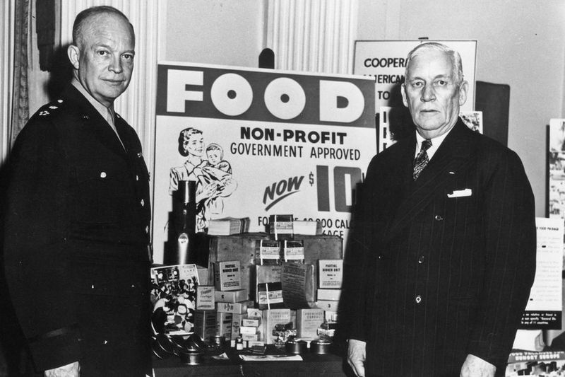Jeneral Dwight D. Eisenhower, kiri, dan Jeneral William Haskell, kanan, berdiri di sebelah bungkusan makanan yang dihantar ke Eropah, yang menghadapi kebuluran selepas kemusnahan Perang Dunia 2.