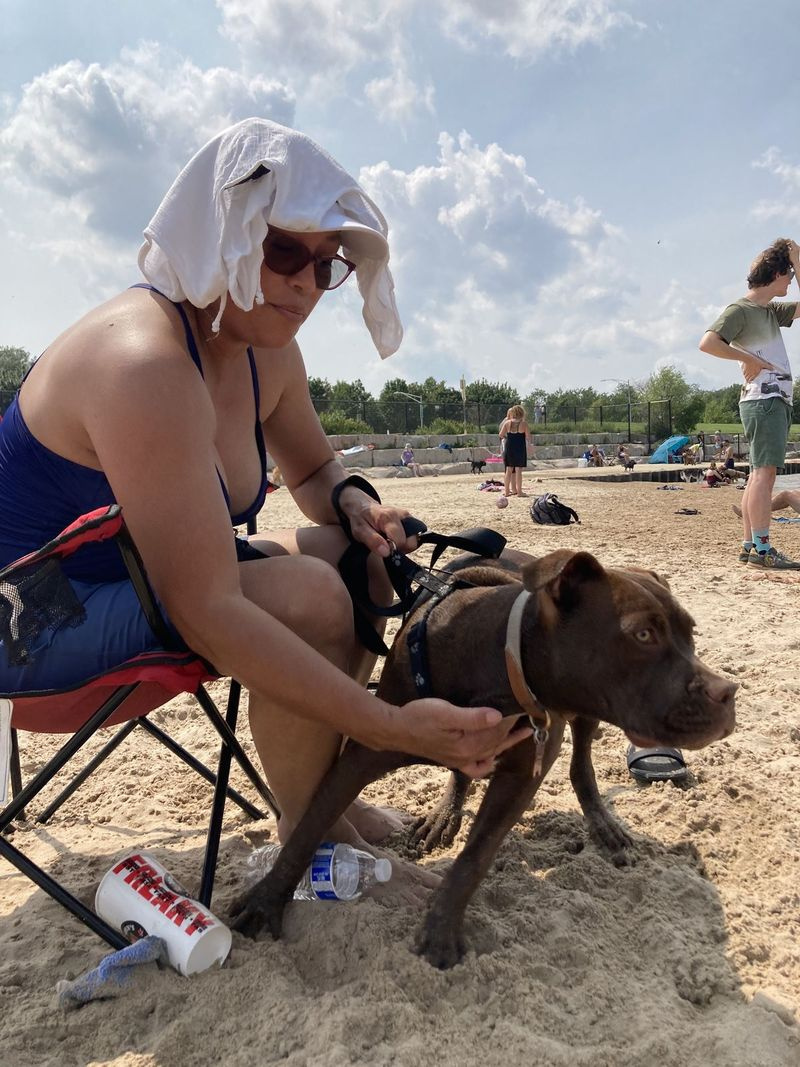 Ingrid Padilla hladká svojho psa Coco na pláži Montrose Dog Beach.
