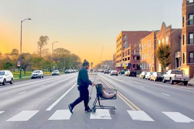 Jarrett Knize mengayuh ikan mas besarnya melintasi North Avenue (melihat ke barat) menuju ke rumah. Kredit: Daisy Schultz