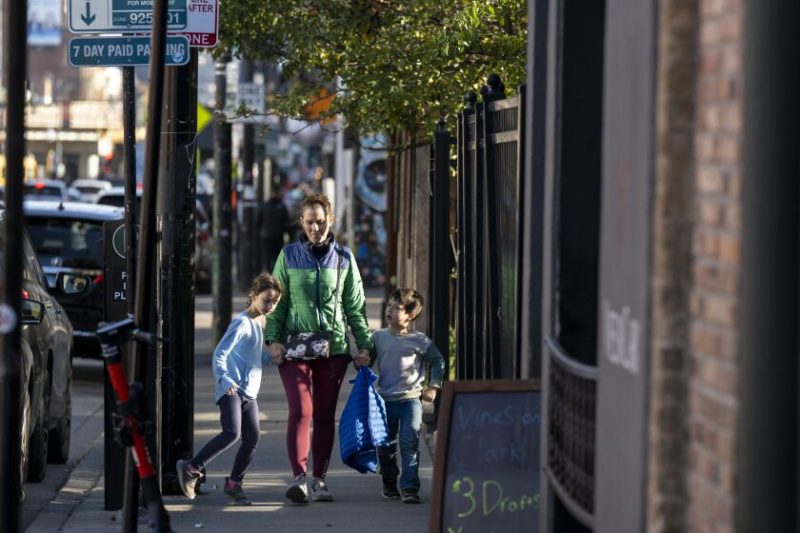   Mensen lopen donderdag 20 oktober door North Clark Street in de buurt van Wrigley Field aan de noordkant. Bedrijfsleiders van Lake View kregen donderdagmiddag meer politieagenten beloofd tijdens een bijeenkomst over een reeks gewapende overvallen net ten zuiden van Wrigley Field in het weekend.