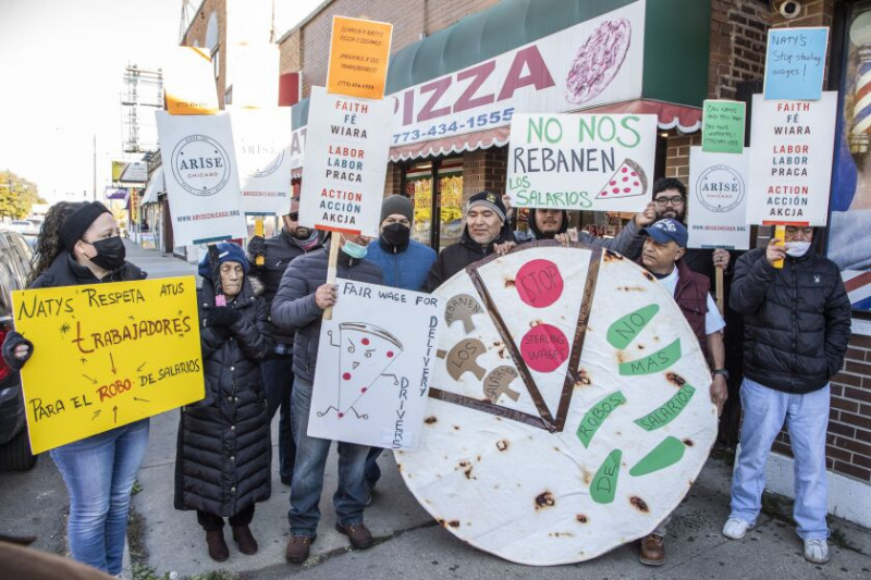   Arbeiders en hun aanhangers van Arise Chicago protesteren buiten Naty's Pizza op 5129 S. Kedzie Ave. in Gage Park, waar vier bezorgers een rechtszaak hebben aangespannen tegen de eigenaar wegens loondiefstal, woensdag 19 oktober.