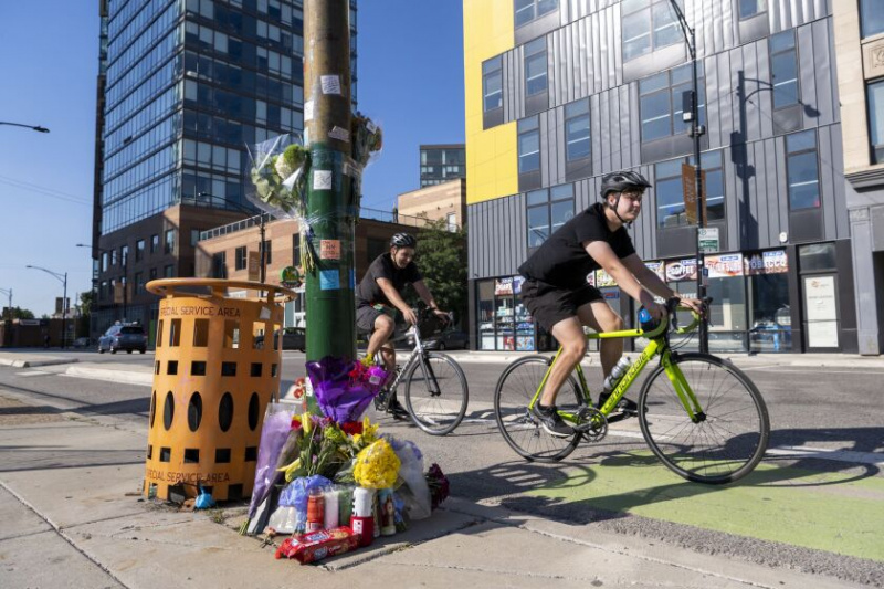   Rowerzyści jeżdżą obok pomnika Sama Bella, w pobliżu miejsca, w którym Bell został uderzony i zabity przez pojazd podczas jazdy na rowerze w 700 przecznice North Milwaukee Avenue, piątek, 9 września.