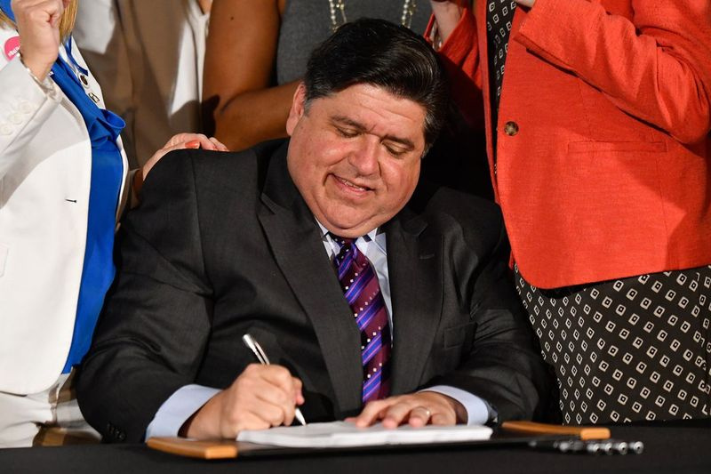 O governador J.B. Pritzker assina um projeto de lei no Chicago Cultural Center em 2019.