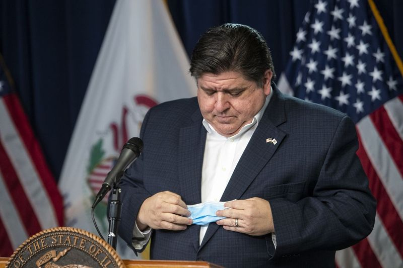 Guvernér J.B. Pritzker odloží svoju tvárovú masku predtým, ako v apríli doručí svoju dennú aktualizáciu o koronavíruse v štáte Illinois v Thompson Center.