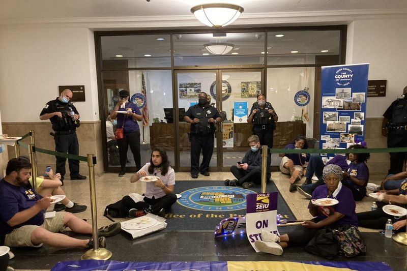 SEIU lokale 73 Cook County-arbejdere spiser pizzær ved sit-in, de orkestrerede uden for Cook County Board-præsident Toni Preckwinkles kontor onsdag eftermiddag i et krav om at afgøre strejken med en kontrakt.