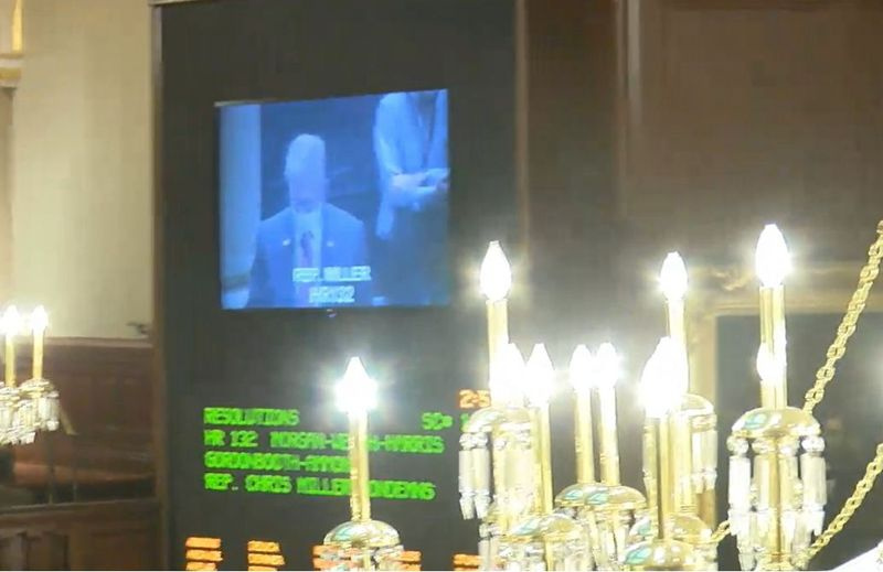Државни посланик Крис Милер приказан је на видео екрану како се брани на поду куће Илиноис у марту неколико тренутака пре него што је веће донело резолуцију којом га осуђује за његове активности 6. јануара.