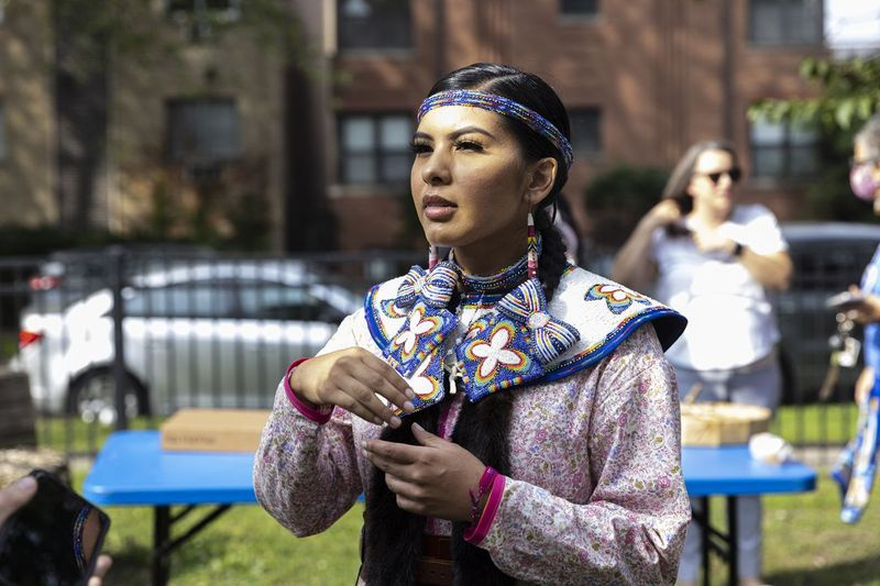 Maritza Garciaová, která sama šila a šila své tradiční šaty, řekla, že svátek měl být již dávno změněn. Garcia mluví o pozadí v Pottawattomie Park na 7340 N. Rogers Ave v Rogers Park na protest poté, co komisaři Cook County odmítli prosadit opatření nahrazující Columbus Day Den domorodých obyvatel, pondělí 11. října 2021. | Anthony Vazquez/Sun-Times
