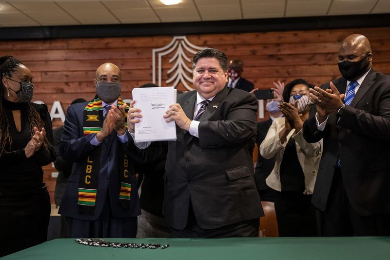 Guvernør J.B. Pritzker holder mandag det næsten 800 sider lange underskrevne lovforslag om reform af strafferetsreformen op på Chicago State University.