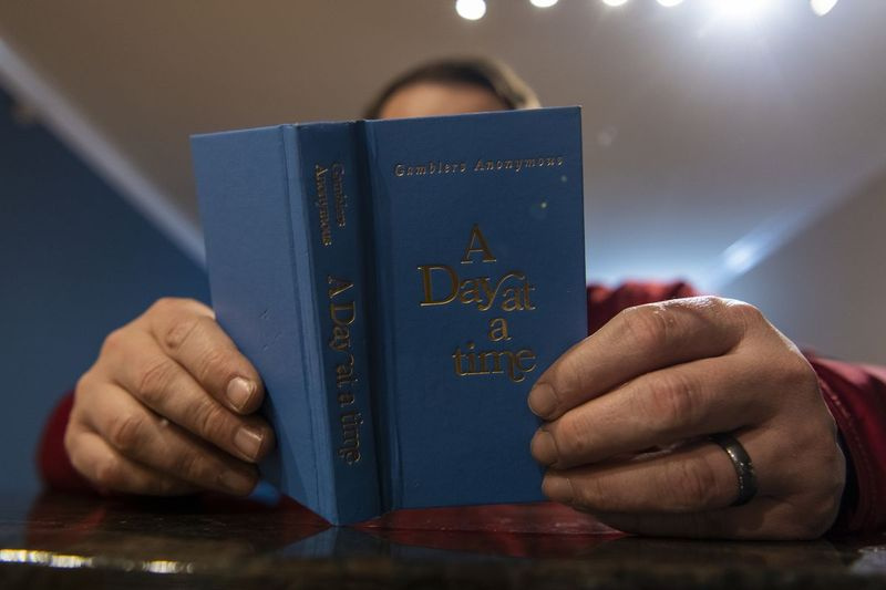Un dependent de jocuri de noroc sportive în curs de recuperare citește pasajele sale preferate din „A Day at a Time”, o carte scrisă de Gamblers Anonymous luna trecută.