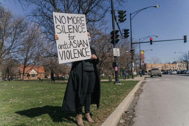 Tina Nguyen, 28 anni, di Logan Square, tiene in mano un cartello per inviare un messaggio il 20 marzo.