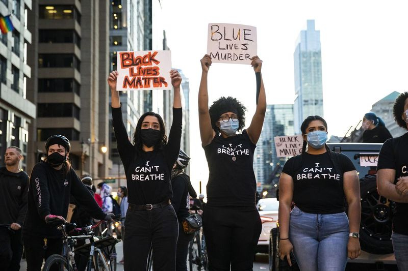 Los manifestantes sostienen carteles en Chicago en mayo de 2020 mientras se unen a la indignación nacional por la muerte de George Floyd.