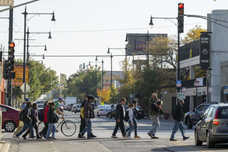   En grupp människor korsar North Central Avenue i stadsdelen Belmont Cragin måndagen den 10 oktober 2022. 