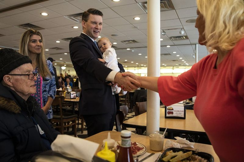 Cooki maakonna osariigi advokaadikandidaat Bill Conway tervitab teisipäeva pärastlõunal valijaid koos naise Brittany ja tütre Bellaga Manny’s Cafeterias ja delikatessipoes.