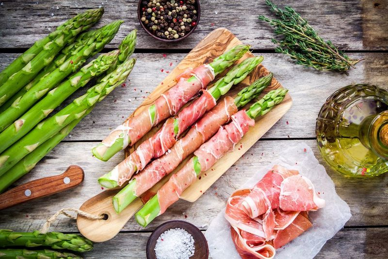 Prosciutto suvynioti šparagai yra lengvai surenkami iš anksto ir paruošti kepti į orkaitę arba ant grotelių, kai būsite pasiruošę patiekti. Jie yra puikus užkandis, kurį galima valgyti, kol ruošiamas likęs patiekalas.