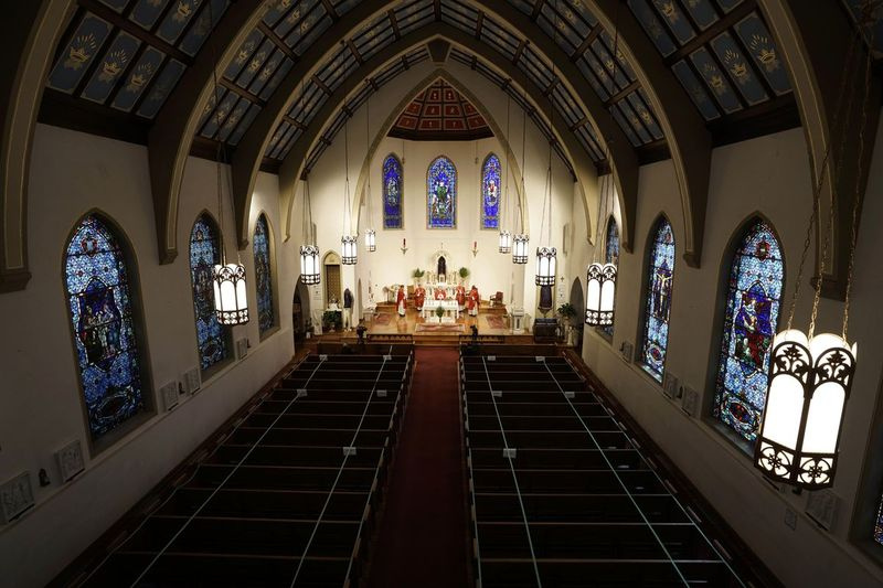 På den här söndagen den 5 april 2020, ett filfoto, genomför The Most Rev. Peter Jugis, biskop av Charlotte, palmsöndagsgudstjänster inne i den tomma St. Patrick Cathedral i Charlotte, NC På grund av coronavirus-pandemin var gudstjänsten stängd för offentligt men livestreamades över västra North Carolina. Katolska enheter i Charlottes stift fick mer än 8 miljoner dollar i löneprogramstöd.