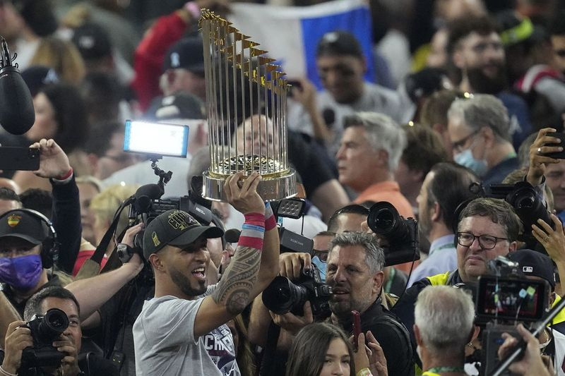 Odvážny ľavý hráč v poli Eddie Rosario drží trofej Svetovej série.