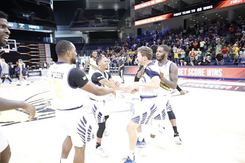 Golden Eagles sa radujú po tom, čo Travis Diener (druhý sprava) predviedol trojku a poslal ich do zápasu o titul na basketbalovom turnaji.