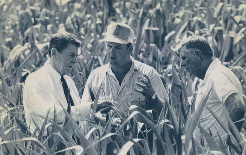 Il presidente Ronald Reagan, a sinistra, osserva da vicino un campo di comunicazioni colpito dalla siccità nel sud dell