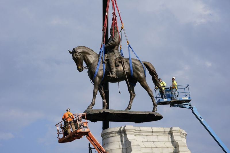 Gli equipaggi lavorano mercoledì per rimuovere uno dei più grandi monumenti rimasti del paese alla Confederazione, una statua imponente del generale confederato Robert E. Lee su Monument Avenue a Richmond, in Virginia.