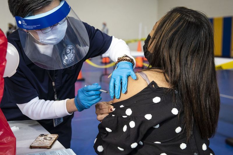 Une femme reçoit sa première dose du vaccin Pfizer-BioNTech COVID-19 au Richard J. Daley College en janvier.