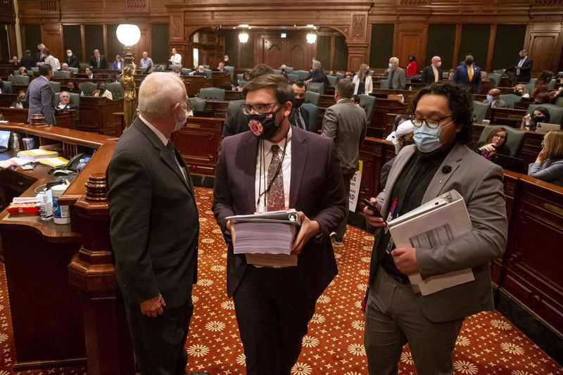 Kakitangan meninggalkan tingkat Dewan Perwakilan Illinois selepas belanjawan diluluskan sekitar tengah malam pada hari terakhir sesi di Illinois State Capitol di Springfield awal Selasa.