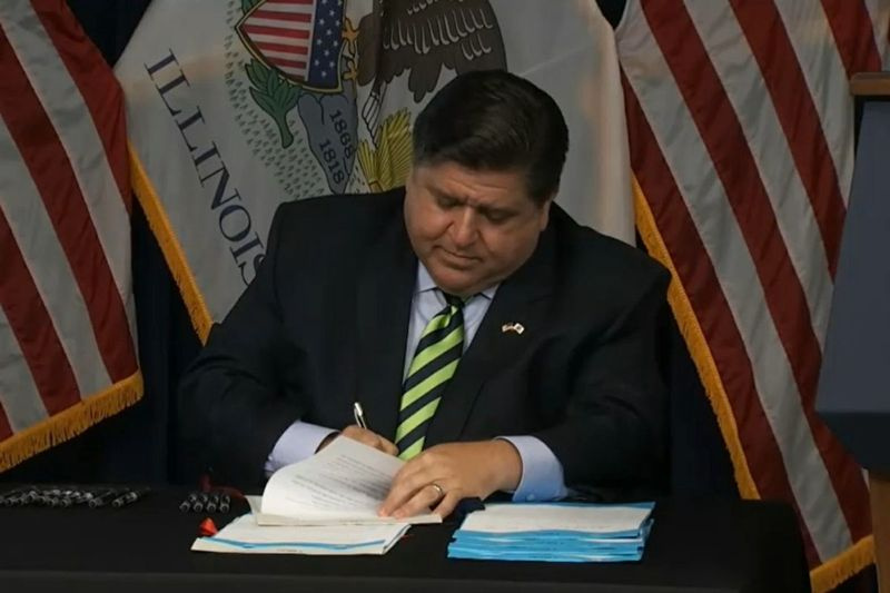 Guvernør J.B. Pritzker signerer en lovpakke som tar sikte på å beskytte og støtte overlevende fra vold i hjemmet ved Thompson Center på fredag.