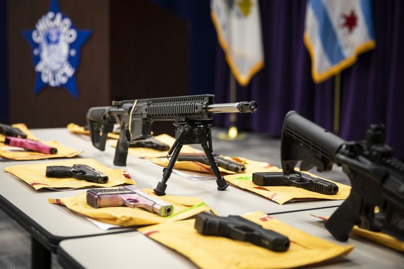 Uma mesa de armas que a polícia de Chicago afirma que policiais confiscados foi exibida durante uma entrevista coletiva na sede da polícia no ano passado.