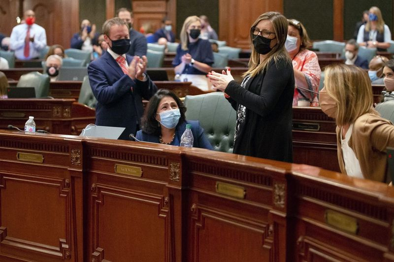 Reprezentantka stanowa Lisa Hernandez, D-Cicero, w centrum, otrzymuje owację na stojąco po przyjęciu propozycji legislacyjnych map stanu Illinois na sali obrad we wtorek wieczorem.
