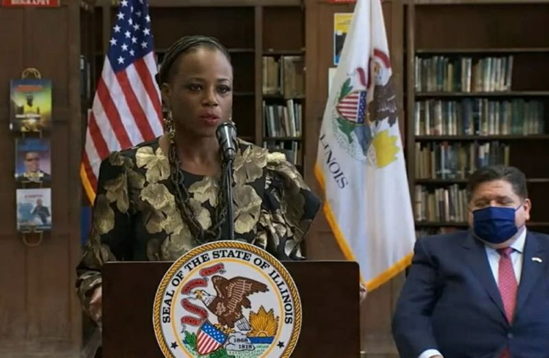 State Rep. Carol Ammons, D-Urbana, spricht bei einer Zeremonie zur Unterzeichnung des Gesetzesentwurfs im letzten Monat, kurz bevor Gouverneur J.B. Pritzker, rechts, den Gesetzentwurf unterzeichnete.
