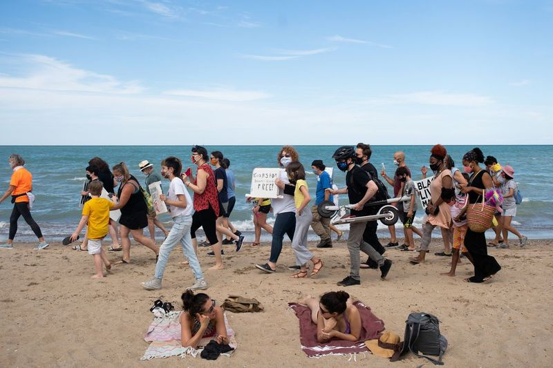 Ludzie biorą udział w wiecu sprawiedliwości rasowej w Lighthouse Beach w Evanston w piątek po południu 31 lipca 2020 r. Po tym, jak LaShandra Smith-Rayfield skonfrontowała się z grupą białych ludzi pokazujących flagę Konfederacji na plaży w środę. | Pat Nabong/Sun-Times