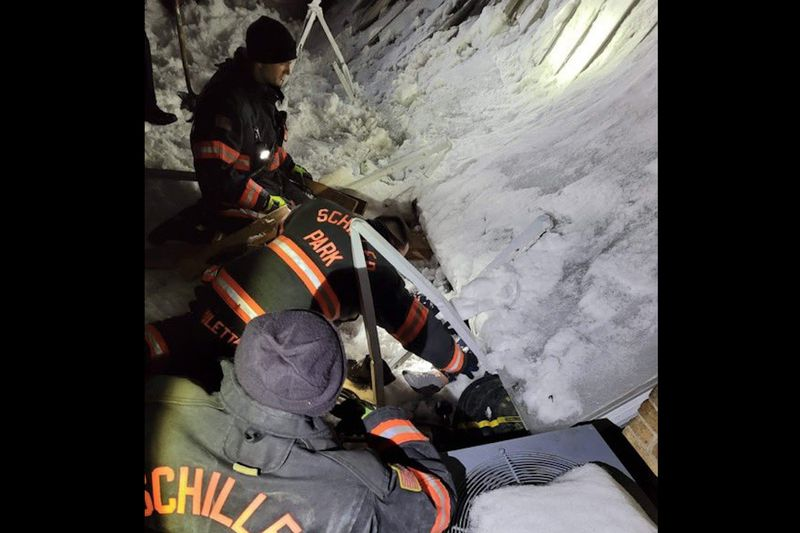 Equipes trabalham para tirar uma mulher de debaixo de um toldo desabado em 22 de fevereiro.