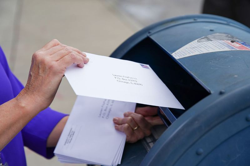 Um repórter do Sun-Times envia um envelope em setembro como parte de um teste do processo de votação pelo correio.
