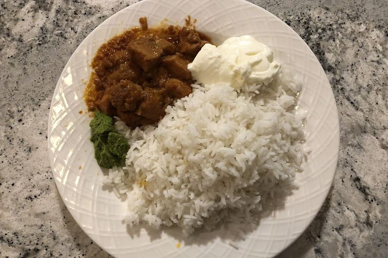 Butterhähnchen von der Mutter des Autors zusammen mit weißem Reis, Joghurt und dem Koriander-Chutney der Mutter des Autors.