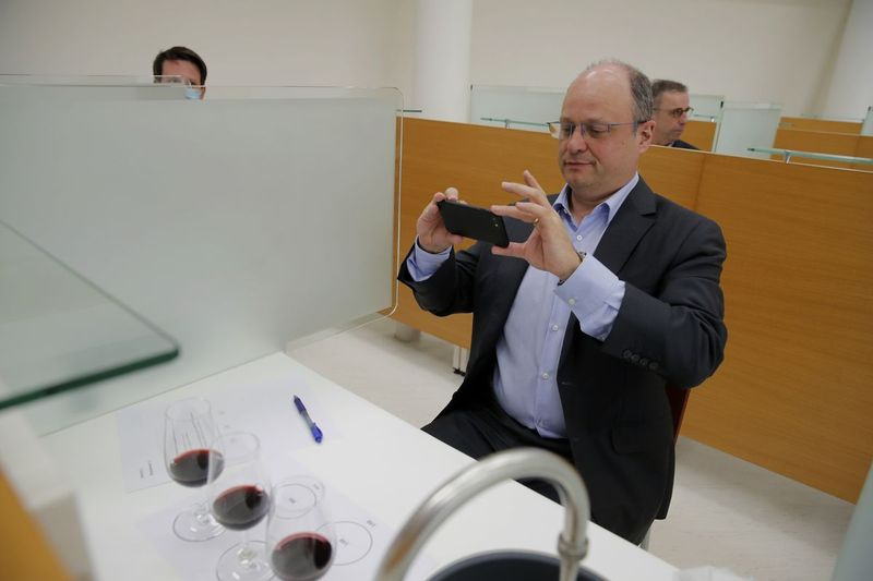 Diretor de Operações do Centro Nacional Francês de Estudos Espaciais (CNES) Lionel Suchet tira fotos de taças de vinho tinto durante uma degustação de garrafas normais e outras que passaram um ano orbitando o mundo na Estação Espacial Internacional