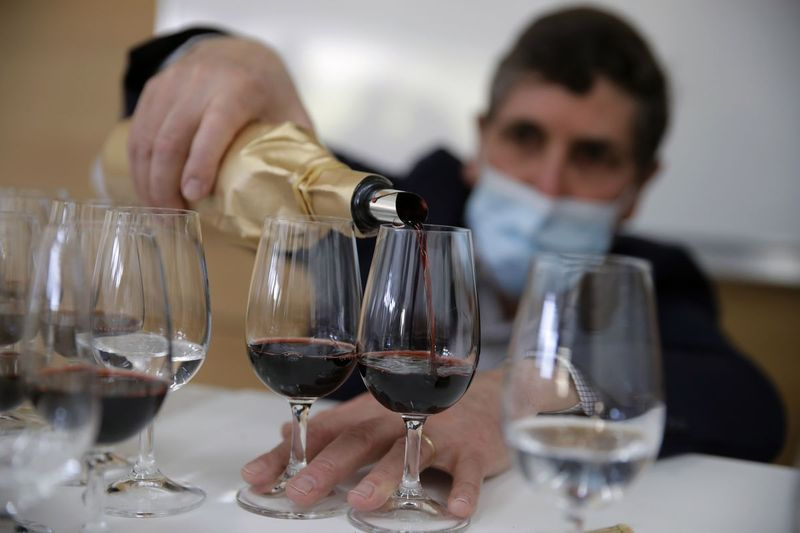 Philippe Darriet, presidente do Instituto de pesquisa de vinhos e videiras e enólogo-chefe enche as taças de vinho para uma degustação às cegas no Instituto ISVV em Villenave-d’Ornon, sudoeste da França. Doze conhecedores provaram um dos vinhos viajados pelo espaço, provando-o às cegas ao lado de uma garrafa da mesma safra que havia ficado em uma adega.