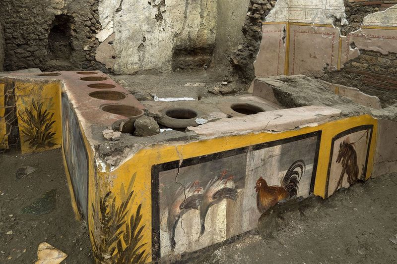 Фотографија коју је ставила на располагање служба за штампу Археолошког парка Помпеје приказује термополијум у археолошком парку Помпеја, близу Напуља, Италија. Ресторан брзе хране откривен у Помпејима сада је потпуно ископан, што помаже да се открију нека омиљена јела грађана старог римског града који су волели да једу вани.