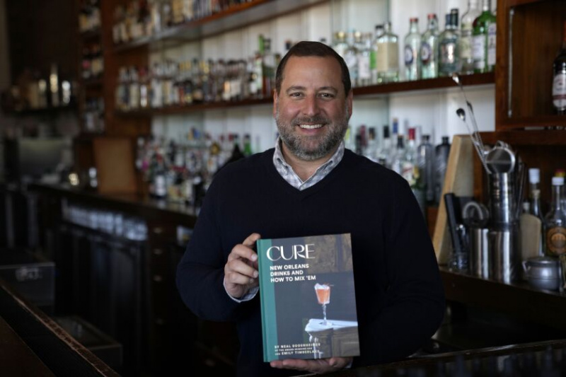   Neal Bodenheimer, ejer og grundlægger af Cure, poserer i sin håndværksmæssige cocktailbar med en kopi af sin nye bog 'Cure: New Orleans Drinks and How to Mix 'Em' i New Orleans.