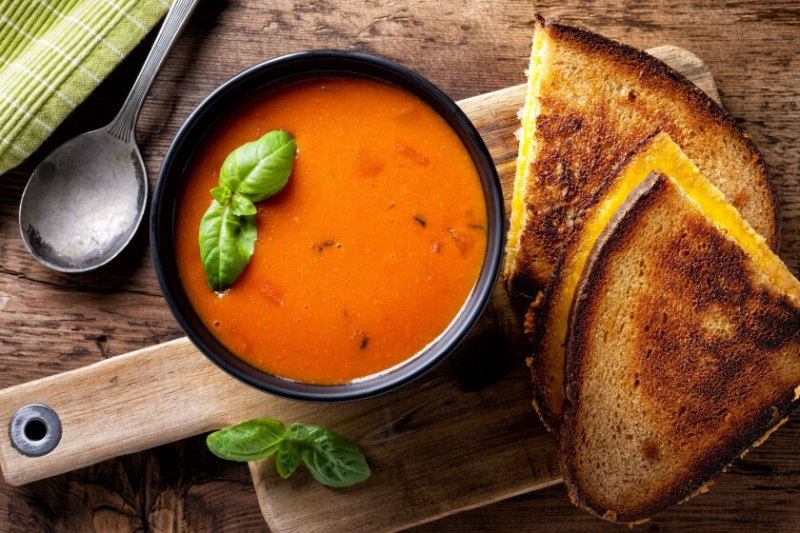   Un abbinamento di comfort food fatto in paradiso: un panino al formaggio grigliato e una scodella di zuppa di pomodoro.