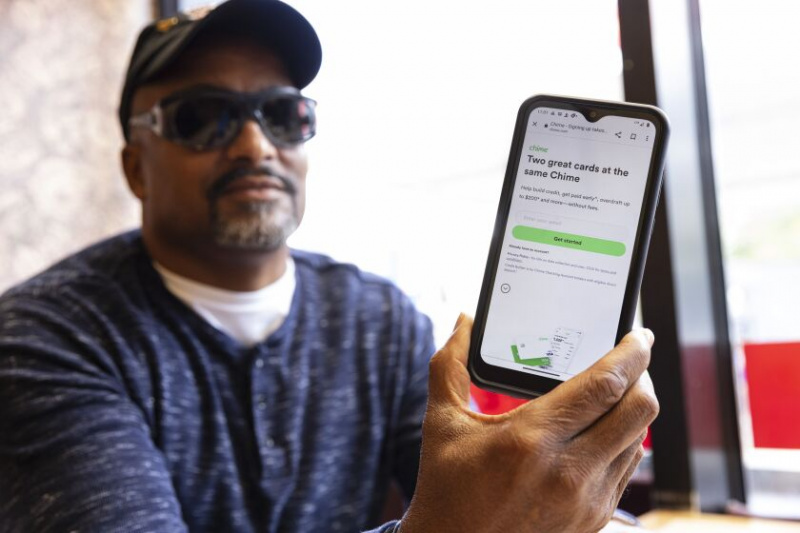   Roderick Woodson från Morgan Park visar appen Chime på sin mobiltelefon. Han säger att han drogs till appens enkelhet och 'no-fee'-modell.