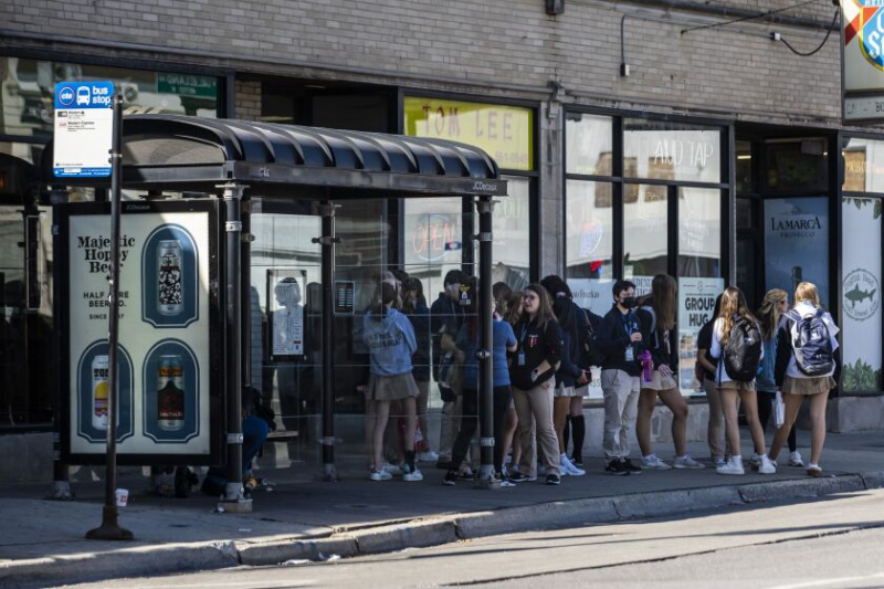   En grupp studenter väntar på en CTA-buss vid en hållplats på North Western Avenue nära West Lawrence Avenue på North Side onsdag eftermiddag den 5 oktober 2022.