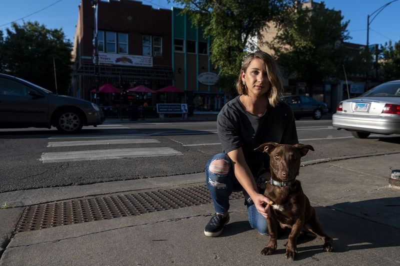 Samantha Basar y su perro posan en la intersección donde fueron atropellados por un automóvil.