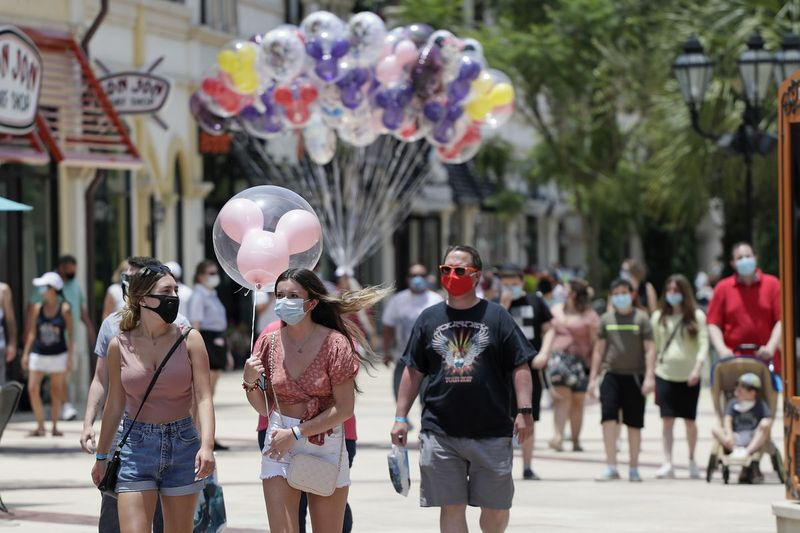 Gostje, ki morajo zaradi koronavirusa nositi maske, se junija sprehodijo po nakupovalnem, restavracijskem in zabaviščnem kompleksu Disney Springs v jezeru Buena Vista na Floridi. Čarobno kraljestvo in kraljestvo živali se bosta ponovno odprla 11. julija.