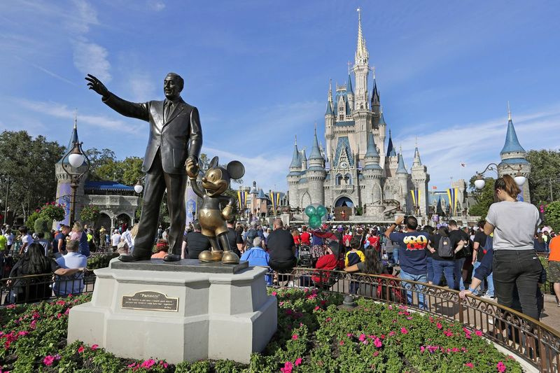 Os convidados assistem a um show perto de uma estátua de Walt Disney e Micky Mouse em frente ao Castelo da Cinderela no Magic Kingdom no Walt Disney World em Lake Buena Vista, Flórida.