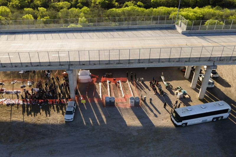 På dette billede taget af en drone ses migranter i varetægt i et amerikansk told- og grænsebeskyttelsesområde under Anzalduas International Bridge, torsdag den 18. marts 2021 i Mission, Texas.