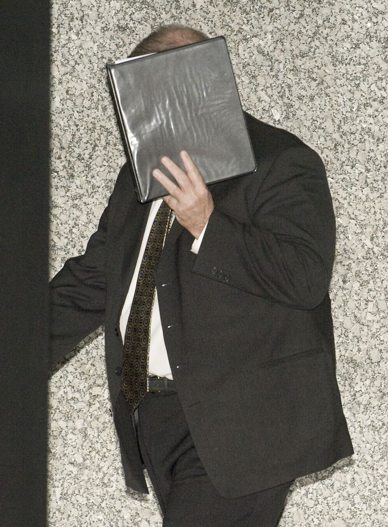 Glenn Lewellen bedeckt sein Gesicht, als er 2011 das Dirksen Federal Building verlässt.