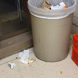 Sebuah tong sampah dibiarkan penuh dengan sampah di atas tanah di Eberhart.