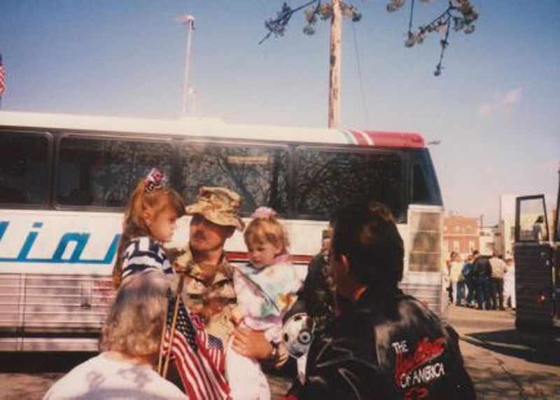 Bruce Coxworth sostiene a sus hijas en Fort Knox, Kentucky, mientras se prepara para el despliegue en la Guerra del Golfo al comienzo de su carrera militar.